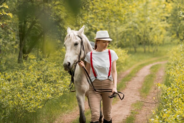 Woman walking with a horse in the countryside 