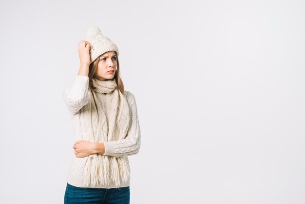 Woman in warm clothes scratching head