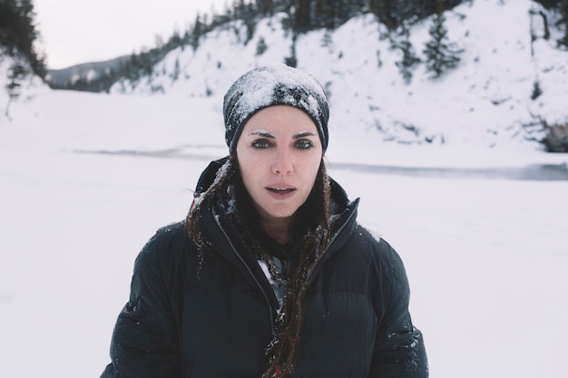 Foto gratuita donna in vestiti caldi su fondo nevoso