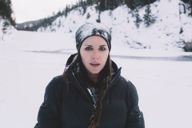 Woman in warm clothes on snowy background