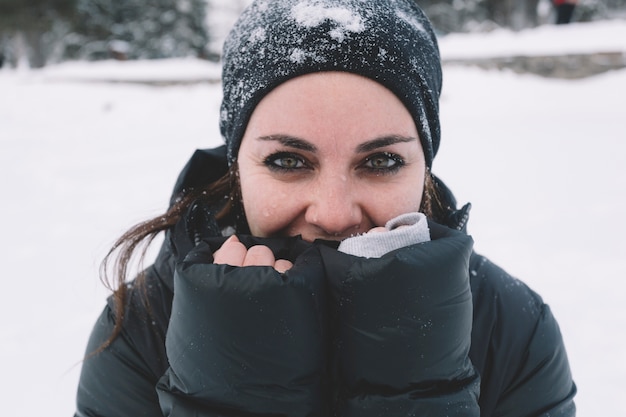 Free photo woman warming hands on snowy background