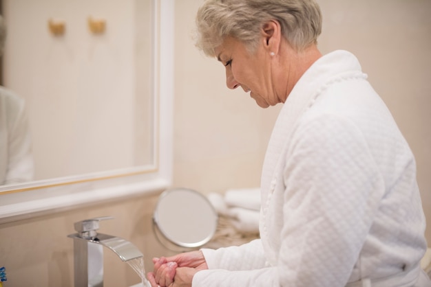 Foto gratuita donna che si lava le mani in bagno