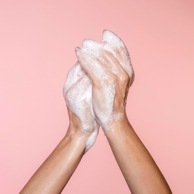 Woman washing hands isolated on pink