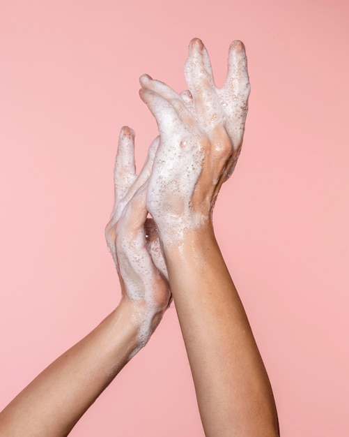 Woman washing hands isolated on pink