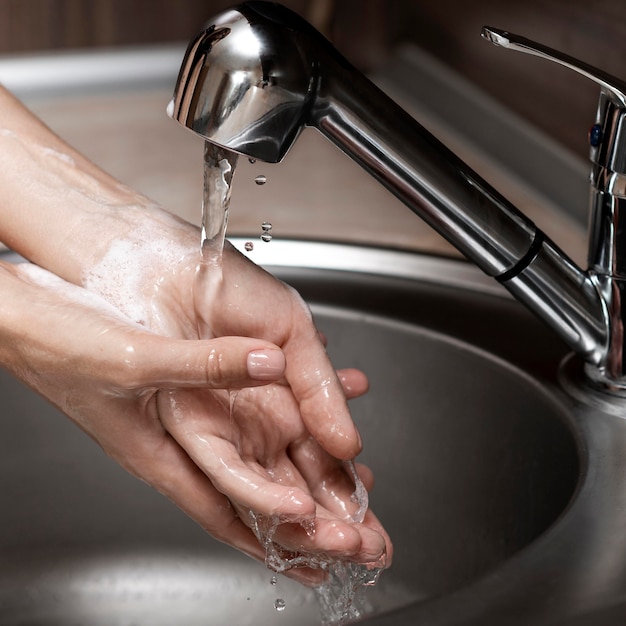 Woman washing hands in a sink close-up