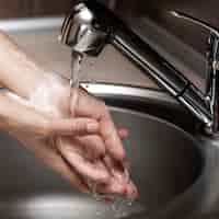 Free photo woman washing hands in a sink close-up