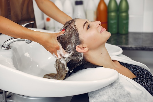 Женщина моет голову в парикмахерской