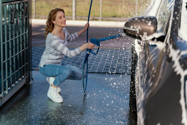 屋外で車を洗う女性
