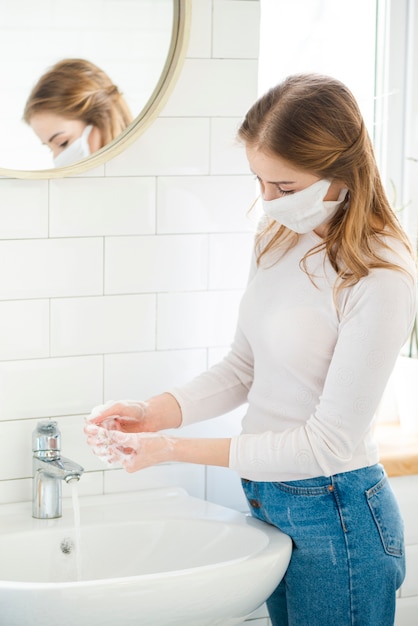 Foto gratuita donna che si lava le mani nel bagno