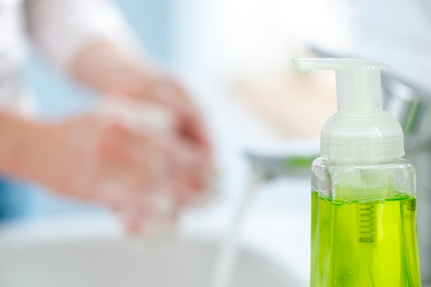 Woman washing her hands with soap