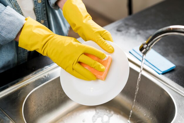 Woman washing a plate in the sink