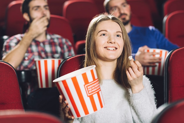 Woman watching movie near men