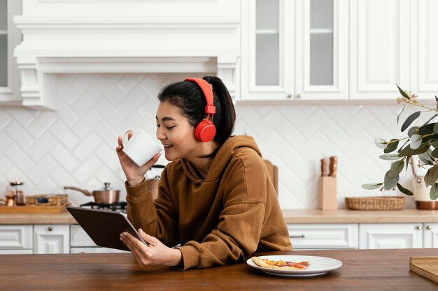 タブレットでビデオを見て、コーヒーを飲む女性