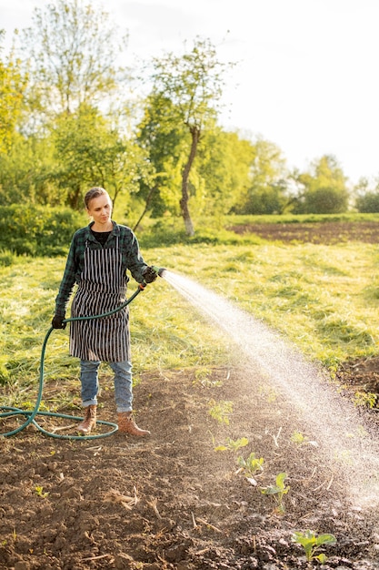 Бесплатное фото Женщина поливает урожай