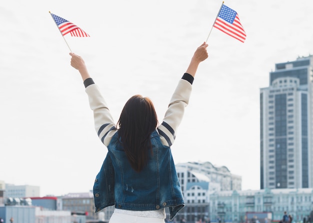 Женщина размахивает американскими флагами в руках
