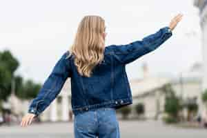 Free photo woman waving her hands from the back shot