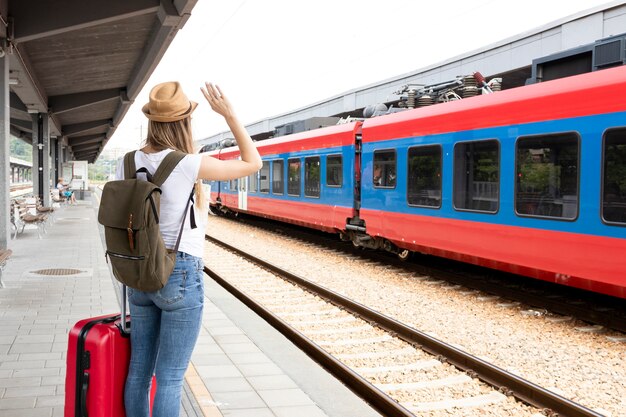 後ろから電車で手を振っている女性