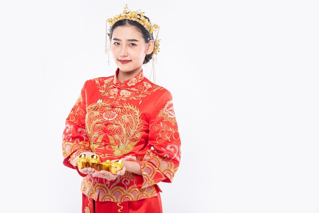 Free photo woman wear cheongsam suit and crown give gold to her family for lucky in chinese new year