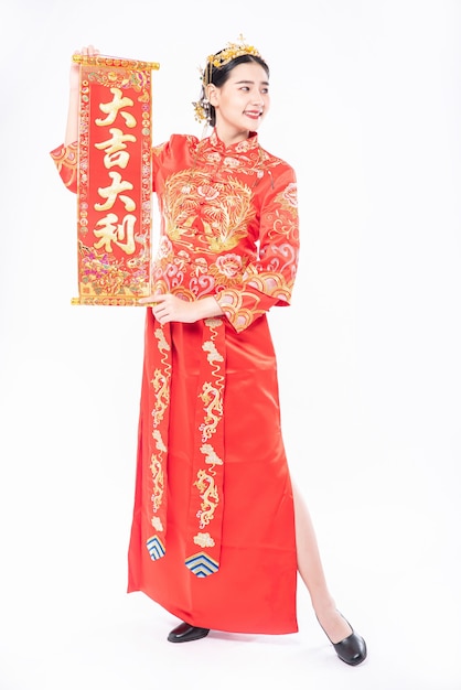 Woman wear Cheongsam suit give family the chinese greeting card for luck in chinese new year