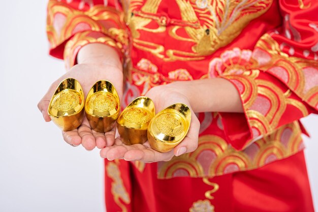 청 삼복을 입은 여성은 중국 새해에 행운을 위해 가족에게 금을 선물합니다.