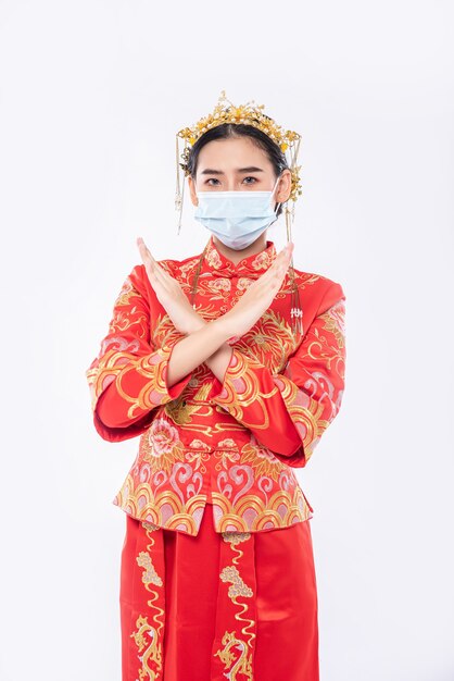 Free Photo woman wear cheongsam suit and mask show people don't wear mask can not be come to shop in chinese new year
