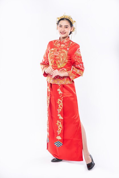 Женщина в костюме Cheongsam улыбается, чтобы поприветствовать путешественника на мероприятии в китайском новом году