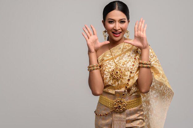 woman wear Thai clothes and open her hands on both sides.