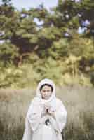 Free photo woman wearing a biblical robe and praying while her eyes are closed