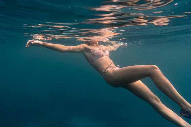 Foto gratuita donna che indossa un bikini come nuotare nell'oceano