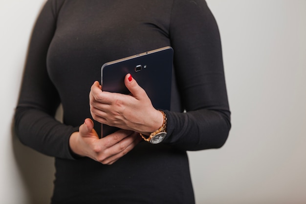 Woman wearing black dress holding tablet