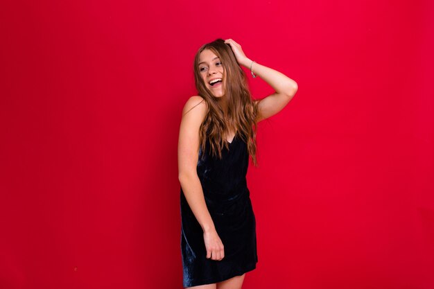 woman wearing a black dress posing on red