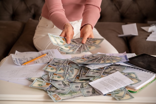 Free photo woman wearing black glasses showing money