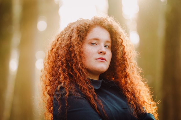 Free photo woman wearing black polo shirt posing in the forest