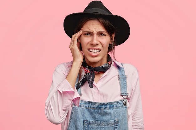 Woman wearing black stylish hat and overalls