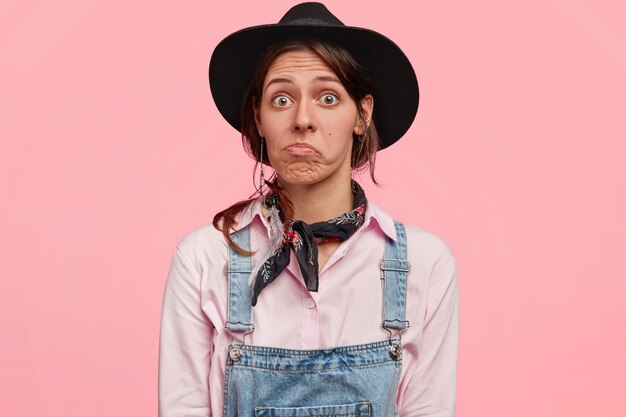 Woman wearing black stylish hat and overalls