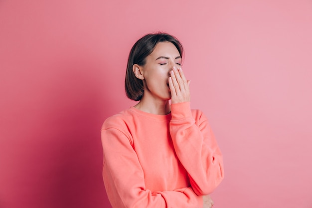 Free photo woman wearing casual sweater on background bored yawning tired covering mouth with hand. restless and sleepiness