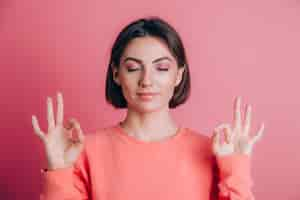 Free photo woman wearing casual sweater on background relax and smiling with eyes closed doing meditation gesture with fingers. yoga concept.