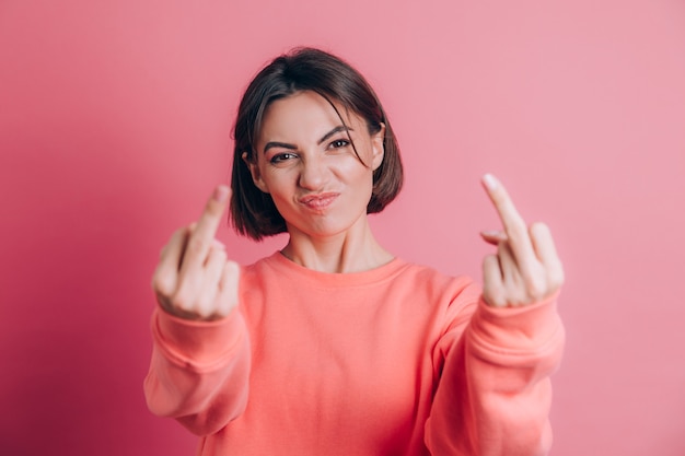 Free photo woman wearing casual sweater on background showing middle finger doing bad expression, provocation and rude attitude