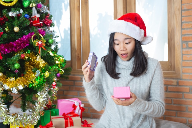 クリスマスプレゼントに満足してクリスマス帽子をかぶっている女性