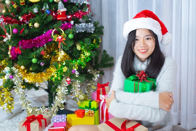 женщина в рождественской шапке счастлива с рождественским подарком