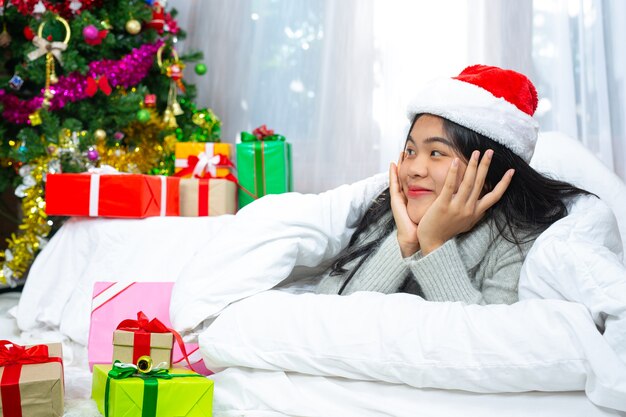 woman wearing christmas hat happy with christmas present