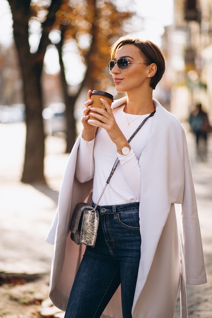 Foto gratuita donna che indossa cappotto e bere caffè