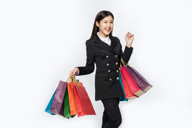 The woman wearing dark clothing, along with many bags, to go shopping