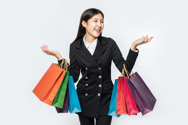 The woman wearing dark clothing, along with many bags, to go shopping
