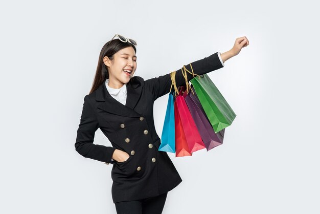 Женщина в темной одежде и с множеством сумок идет за покупками