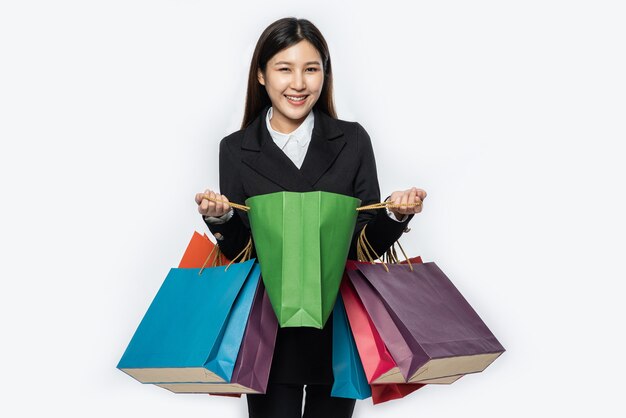 買い物に行くために、たくさんのバッグと一緒に暗い服を着ている女性