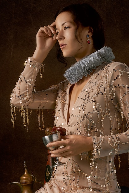 Woman wearing an Elizabethan collar and carrying a chalice filled with grapes 