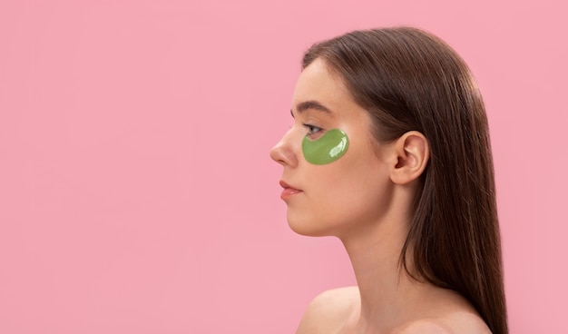 Free photo woman wearing eye patches side view