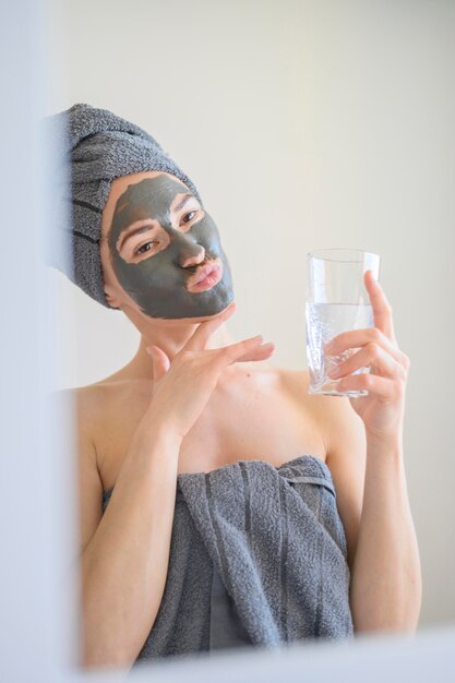 Woman wearing face mask making faces in the mirror