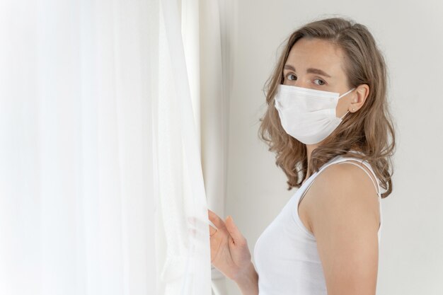 woman wearing Face Mask to protect  feeling sick headache and cough because of Coronavirus covid-19 in quarantine room